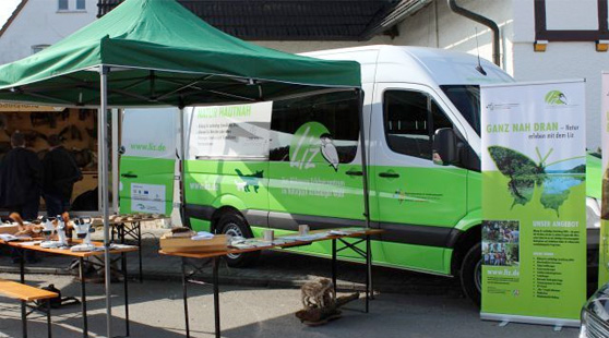 Blicka auf den Infostand Umweltmobil-Stand mit Rollup, Banken und Tischen mit Materialien